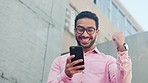 Excited, happy and cheering man celebrating a successful stock market trading profit on a phone in a city. Low angle view of an amazed cryptocurrency investor looking surprised after winning lottery