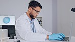 Latex, health and safety view of male scientist typing on computer. Focused, hygenic working adult man using protective gear on laptop. Male protecting hands from bacteria and germs at work indoors.