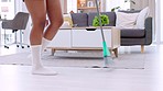 Cheerful, fun and happy closeup of female legs dancing across clean floor with broom. Celebrating finished chores, while alone at home, in living room. Excited after completing a day of housework
