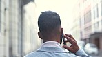 Stylish and successful businessman talking on call while waiting and looking around outside alone in the city. Rear view of entrepreneur or startup owner chatting on phone before meeting a client