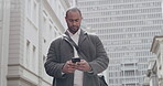 Casual man reading text on phone, typing a message and checking social media while standing in the city alone. Serious black male browsing internet, chatting online and looking for location downtown