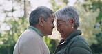 Happy, romantic and senior couple in love, bonding and enjoying the outdoors showing their happiness together. Smiling, loving and mature husband and wife connecting and touching foreheads in nature