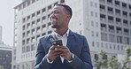 Corporate business man typing text on phone, reading a message and thinking while standing in the city before work. Professional employee smiling, scrolling on social media and updating status online