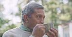 Carefree senior man drinking coffee in nature, relaxing with tea in a garden and looking at the view in a park. Relaxed, retired and mature male enjoying a day outside in summer and thinking
