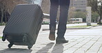 Businessman with suitcase or luggage, walking to destination while on a business trip in a modern, urban city street. Low angle legs of a professional formal man with travel baggage arriving overseas