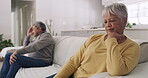 Unhappy, arguing and depressed senior couple upset and ignoring each other while sitting on the couch after a fight at home. Angry husband and wife worried about financial problems during retirement