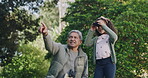 Family bonding, exploring with binoculars, grandfather on outdoor adventure with grandchild. Retired senior bonding with his grandkid while exploring nature and wildlife together in a park or forest