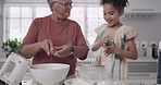 Grandmother and child baking, cooking and making a cake, dessert and homemade cookies or biscuits in a home kitchen. Cute, fun and little girl helping elderly senior, bonding and learning how to bake
