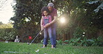 Learning, teaching and bonding of a grandfather showing a little girl a golf player swing outside. Active, playing and leisure activity of a loving family having fun together in an outdoor garden