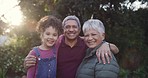 Smiling, happy and loving grandparents bonding with their cute granddaughter in a park, garden or yard on a sunny day outdoors. Portrait of a loving family relaxing, laughing and having fun together