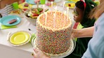 Birthday celebration cake at kids party with fun, colorful decoration. Boy child celebrating his special day or occasion with friends by blowing out candles and enjoying sweet baked snack food