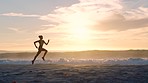 Active, fit and sporty athlete running on beach shore with waves, sunset background and copy space. Shadow, outline and silhouette of a healthy woman with stamina doing workout, exercise and training