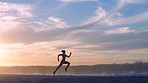 Active, fit and sporty athlete running on beach shore with sunset sky background and copy space. Shadow, outline and silhouette of a woman with stamina doing workout, exercise and training by the sea