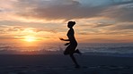 Fast, fit and active jogger running by the ocean and beach shore with sunset sky background and copy space. A sporty female athlete exercising or doing endurance workout outdoors with a scenic view