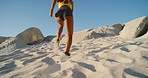 Closeup of an active and healthy woman running on the beach on a sunny day with blue sky. Female athlete enhancing her endurance by training on dune sand. Triathlete building stamina for next race.