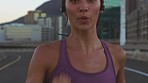 Runner, athlete and city woman listening to music in the, street or road while running. Health, cardio and wellness with exercise girl training for competition, marathon or sports workout in town.