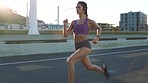 Running, fitness and runner workout of a woman training in a city street. Sport motivation and focus of a healthy, strong and sports athlete exercise for health, cardio and wellness on a urban road