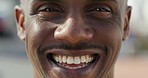 Closeup portrait of happy, excited and friendly black man face smiling with teeth. Handsome African American male smiling or laughing with wrinkled eyes at a joke or something funny, having fun.
