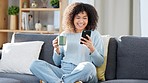 Woman reading a text message on a phone, scrolling on social media online or browsing an app while drinking coffee at home. One happy, smiling and comfy black female searching the web with tea