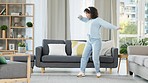Free, happy and relaxed woman dancing to music with headphones, having fun at home. Black female enjoying weekend, using dance to exercise and express joy. African American woman with lots of energy