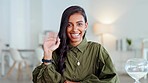 Young business woman waving hand and greeting on a videocall or zoom meeting while sitting in an office. Portrait of a beautiful and elegant female entrepreneur waves her palm on a virtual conference