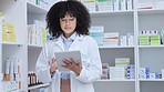 Smiling, young medical healthcare pharmacist, working on inventory on digital tablet in modern pharmacy store. Portrait of friendly female doctor standing in modern medicine drugstore dispenser