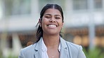 Confident professional and corporate business woman laughing while standing outside with blurred bokeh background. Face portrait of a happy hispanic female entrepreneur looking cheerful about success