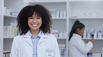 Pharmacist, healthcare worker or medical student doctor smiling in a pharmacy. Young, happy and cheerful afro clerk standing with medicine and pills for patients pain, healing and wellness behind her