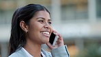 Happy businesswoman talking on a phone call, outdoors in the city. Beautiful female smiling, laughing and speaking and receiving good news, walking outside an office, with copy space background