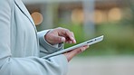 Writing, typing and texting closeup of a businessperson holding a tablet outside connected and networking on the go using modern technology chatting app. One corporate worker sending an email message