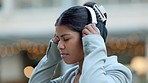 Happy, fun and free young woman dancing while listening to music with headphones. Excited female celebrating good news, feeling positive, carefree and expressing joy while taking a break in the city