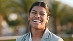 Confident professional and corporate businesswoman laughing while standing outside with blurred bokeh background. Face portrait of a happy latin female entrepreneur looking cheerful about success