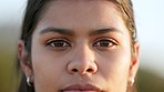 Closeup face of laughing, smiling and happy woman or volunteer looking forward with caring, friendly and kind facial expression. Portrait headshot of a carefree lady with brown eyes standing outside