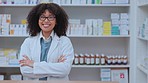 Proud, confident and happy pharmacist smiling while standing in a drugstore or pharmacy with copy space. Portrait of satisfied African female healthcare professional with a smile at a dispensary
