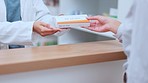 Pharmacist handing prescription medication, pills or medicine to customer inside a pharmacy, clinic or drug store. Medical professional or pharmaceutical giving a patient antibiotics product closeup