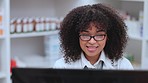 Pharmacist, medical and healthcare professional with computer in pharmacy reading, researching and learning about new medicine. Smiling, happy and friendly afro woman typing in a medication drugstore