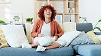 Entertainment, laughter and fun at home with a black woman watching tv, laughing and relaxing on a sofa. Young, happy female enjoying a snack, eating popcorn and smiling at a funny movie or series