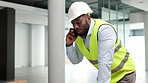 Construction worker, building contractor or engineer talking on a phone while working on a build site. Young male builder answering a call while planning a renovation, remodel or new development
