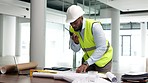 Architect, building engineer or construction worker looking at plans and blueprints and talking on a radio. Male contractor planning, instructing and giving orders while working on a build site