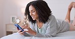 Social media, phone and bed with young black woman relax, smile and online lying in bedroom at home. Internet, web and communication with female reading email, streaming, text or app