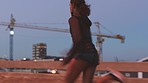 Woman running for fitness motivation in urban city, training for a marathon competition at night and doing cardio for strong and healthy body on dark road. Sprinter sprinting fast and with speed