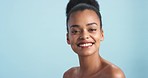 Happy black woman, smile and beauty in skincare, health and wellness against a blue studio background. Portrait of a African female face smiling with teeth in happiness for cosmetic spa treatment