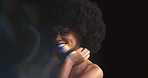 Rainbow, prism light and reflection on a black woman model with natural hair and smile. Happy female with colorful lighting on her face, teeth and body posing with art lights on black background