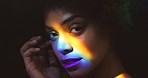 Rainbow face, woman and portrait of beauty makeup with optical flare in studio for pride campaign. Sensuality, equality and lgbt black person with a fantasy colorful light effect on skin.