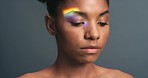 Natural beauty, activism and rainbow light or ray on face of black woman against a grey background. Portrait and skincare, lgbtq and gender identity or expression of a serious and strong female