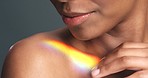 Rainbow light on black woman model glow healthy skin from wellness cosmetics skincare makeup gradient product. Macro makeup artist hand on shoulder with prism iridescent color pattern beauty tutorial