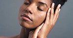 Black woman hands touch sensual face or skin against a grey studio background. Beauty model feeling her soft, smooth and healthy body after cosmetic facial skincare for wellness and positive results