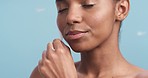 Beauty, skincare and feather soft skin of a African woman feeling satisfied with healthy, glowing and smooth face against blue background. Natural model happy with moisturizer or dermatology routine