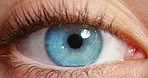 Closeup of a woman opening her blue eye with her pupils dilating with beautiful long eyelashes. Macro zoom of a girl with optical eyesight and a human eyeball vision with a iris, sclera and tear duct