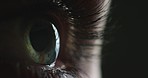 Eyes, vision and dark with an eye of a woman in a test or exam for prescription eyewear or contact lenses at the optometrist or optician. Female testing for eyesight in a studio on a black background